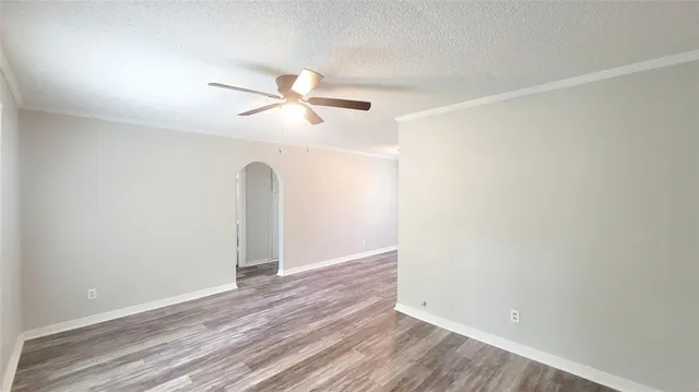 an empty room with a window and ceiling fan
