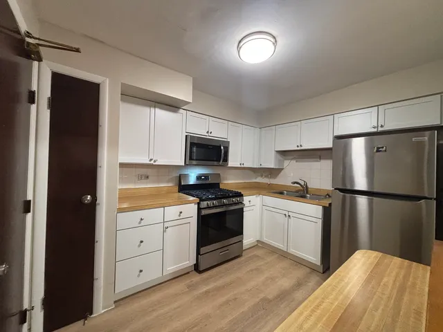 a kitchen with white cabinets and white appliances