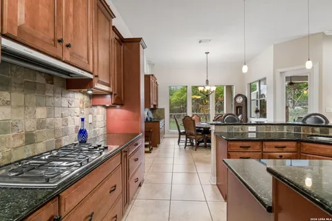 a kitchen with stainless steel appliances granite countertop a stove a sink and a wooden cabinets