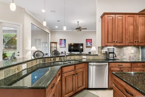 a kitchen with kitchen island granite countertop a sink stainless steel appliances and cabinets