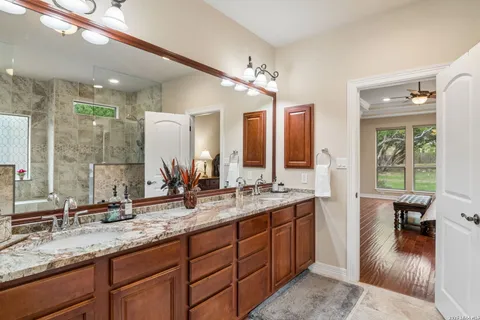 a bathroom with a sink double vanity granite and a large mirror