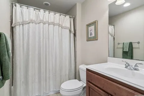 a bathroom with a granite countertop sink toilet and a mirror