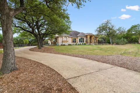 a front view of a house with a yard and trees