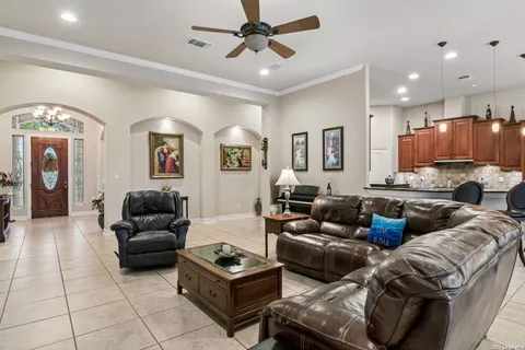 a living room with furniture kitchen view and a chandelier