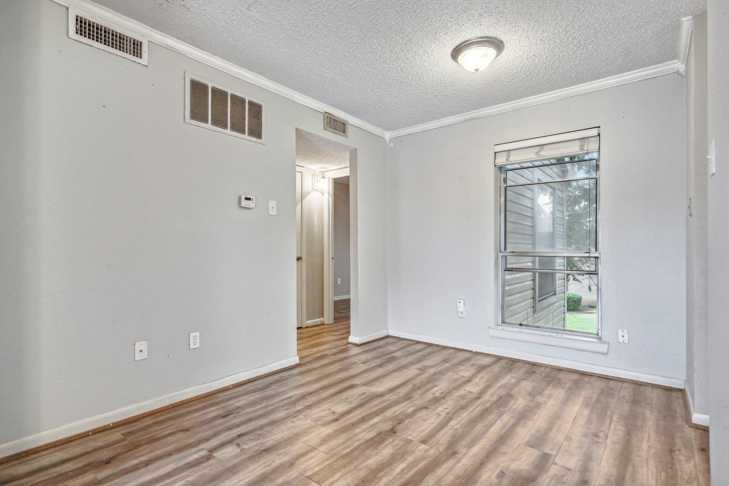 1701 Ridge Oak Place, Unit 4 Memphis, TN 38120 - Photo 6 of 21 a view of an empty room with a window and hardwood floor