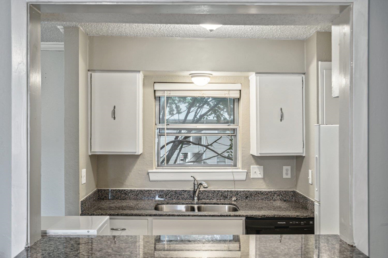 1701 Ridge Oak Place, Unit 4 Memphis, TN 38120 - Photo 7 of 21 a kitchen with a granite countertop sink and window