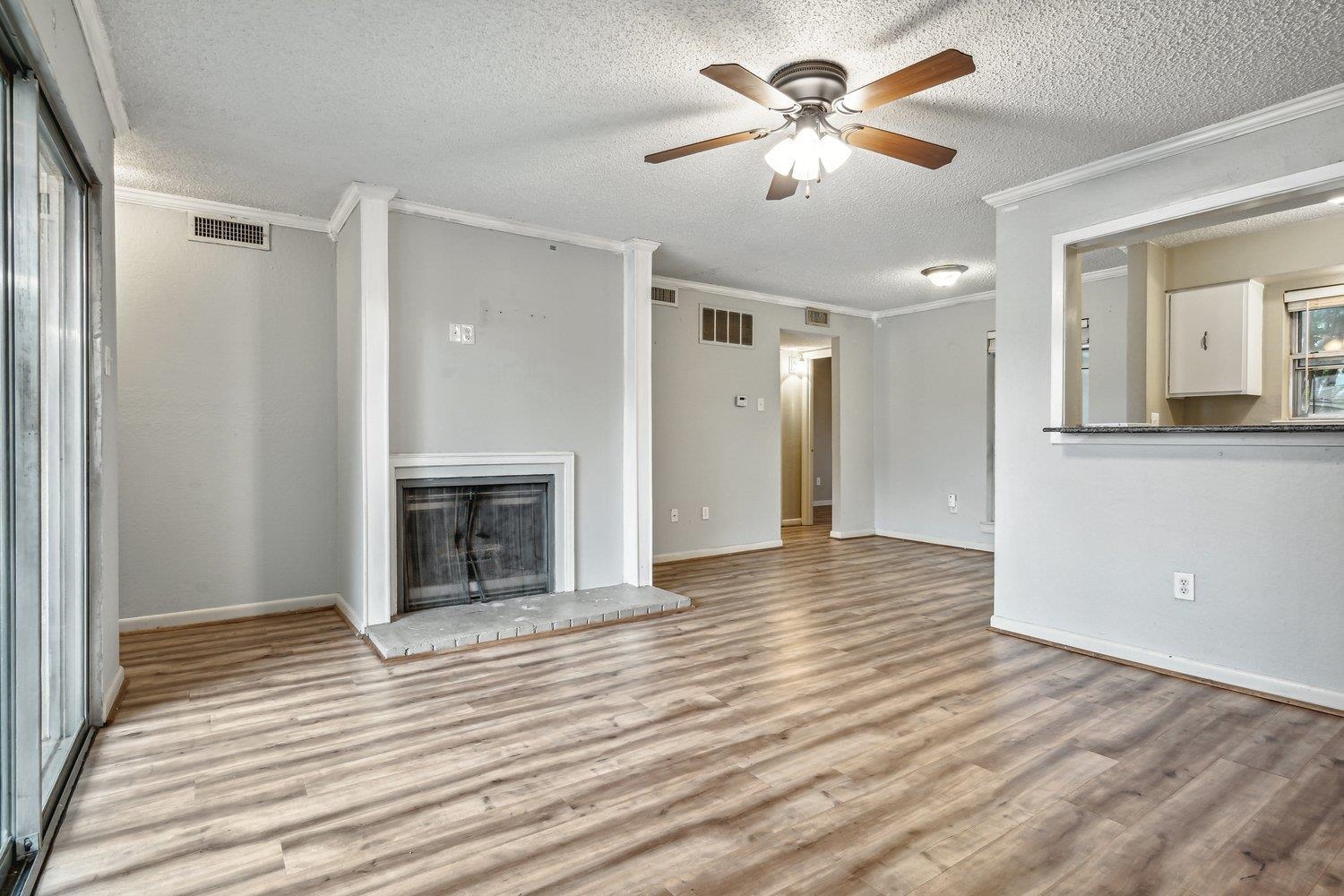 1701 Ridge Oak Place, Unit 4 Memphis, TN 38120 - Photo 8 of 21 a view of a livingroom with a fireplace a ceiling fan and brick walls