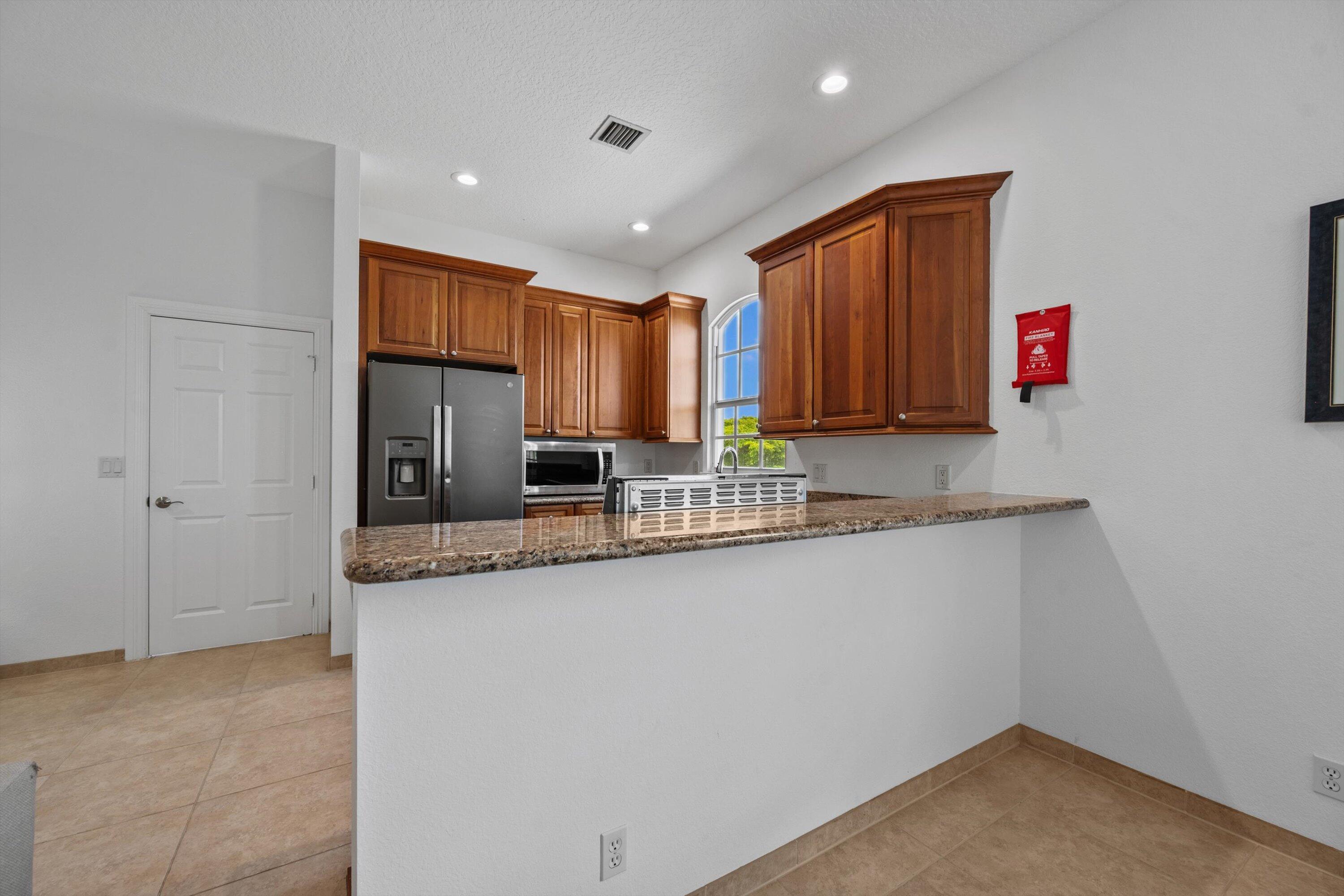 3287 Grande Road Loxahatchee, FL 33470 - Photo 54 of 126 a kitchen with granite countertop a sink and a refrigerator