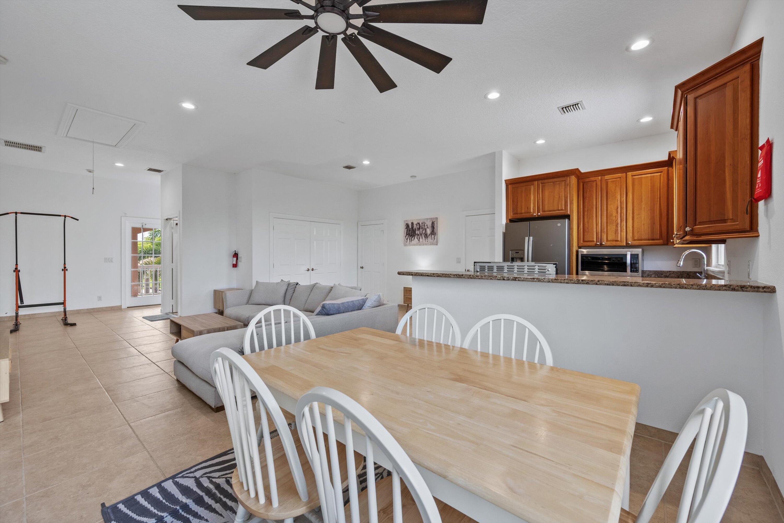 3287 Grande Road Loxahatchee, FL 33470 - Photo 56 of 126 a kitchen with stainless steel appliances a table and chairs