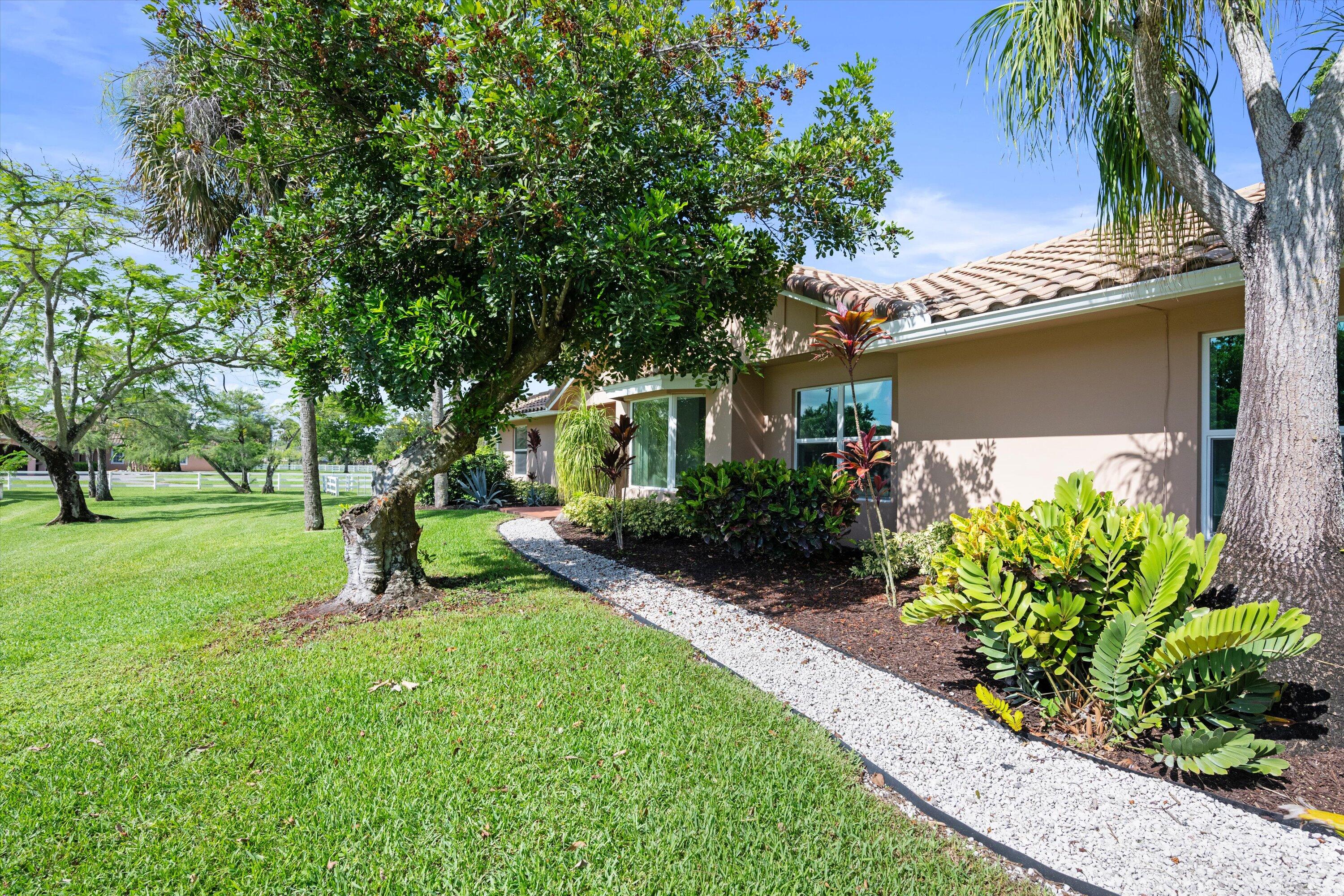 3287 Grande Road Loxahatchee, FL 33470 - Photo 74 of 126 a front view of a house with garden