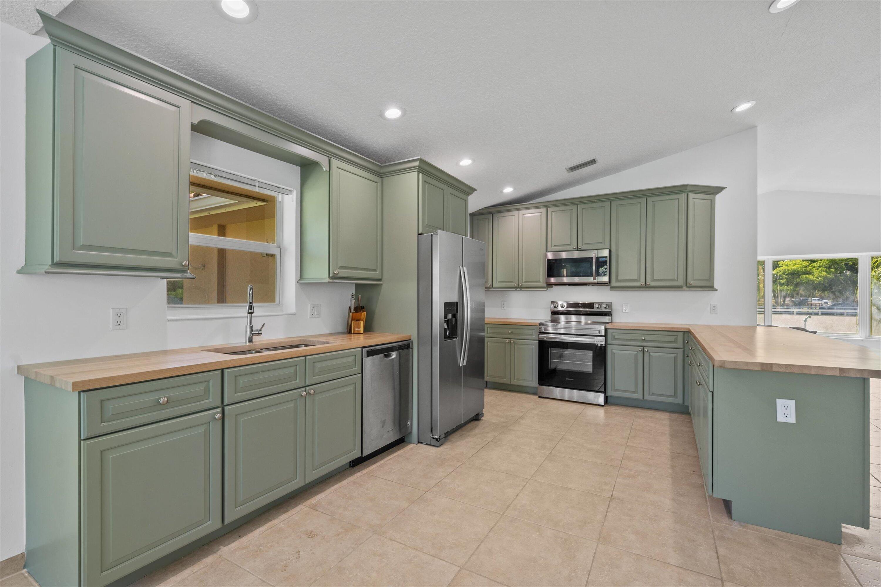 3287 Grande Road Loxahatchee, FL 33470 - Photo 77 of 126 a kitchen with a sink cabinets and stainless steel appliances