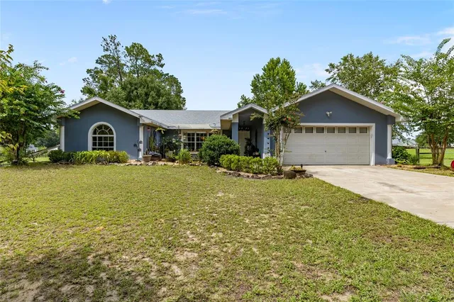 a front view of a house with a yard and trees