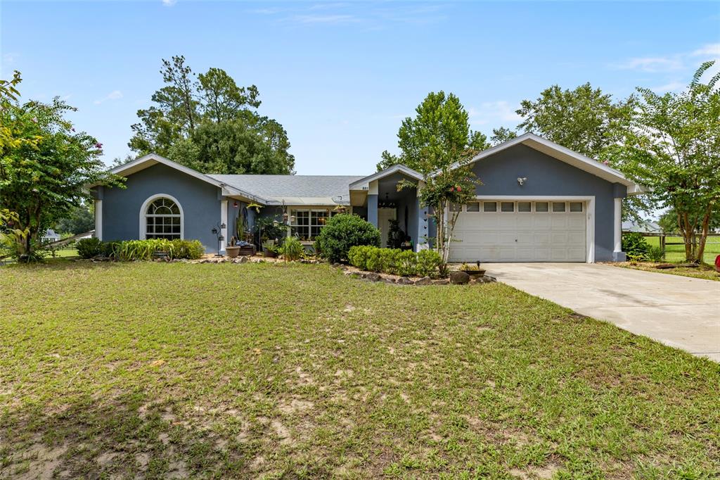 a front view of a house with a yard and trees