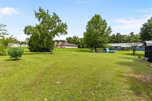 a view of yard with swimming pool and green space