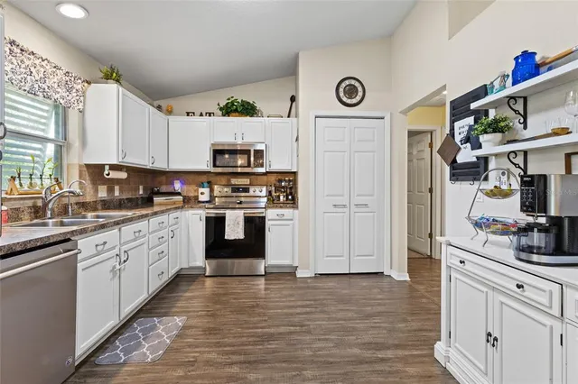 a kitchen with stainless steel appliances granite countertop a refrigerator and a stove top oven