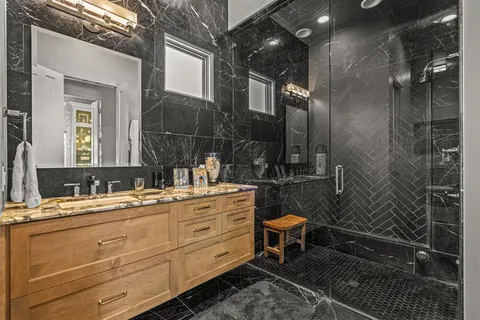 a bathroom with a granite countertop sink mirror vanity and toilet