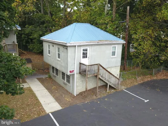 a view of a house with backyard and trees
