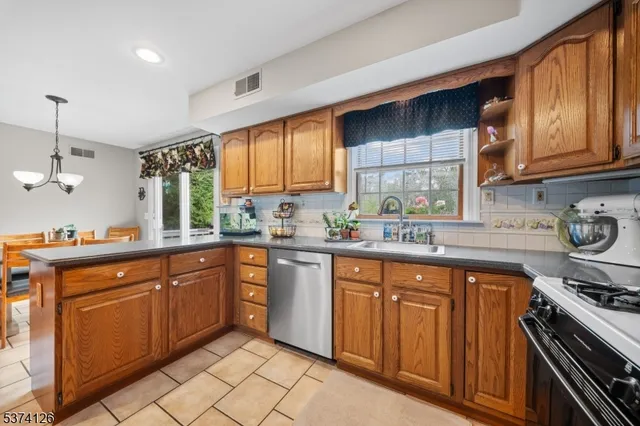 a kitchen with stainless steel appliances granite countertop a stove a sink dishwasher and a microwave oven with cabinets