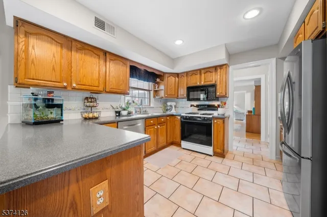 a kitchen with stainless steel appliances granite countertop a refrigerator stove top oven a sink and dishwasher