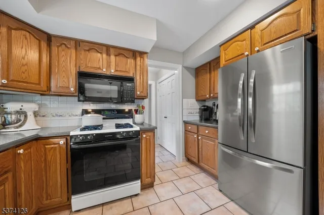 a kitchen with stainless steel appliances granite countertop a stove a refrigerator and a sink