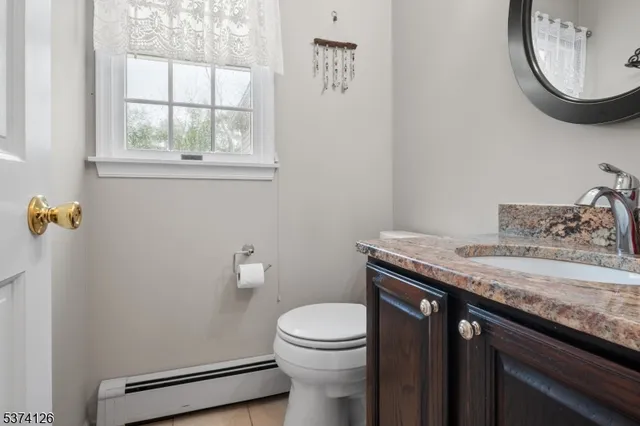 a bathroom with a granite countertop toilet a sink and a mirror