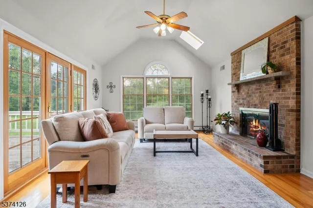 a living room with furniture a fireplace and a floor to ceiling window