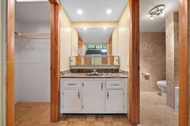 a bathroom with a granite countertop bathtub shower and toilet