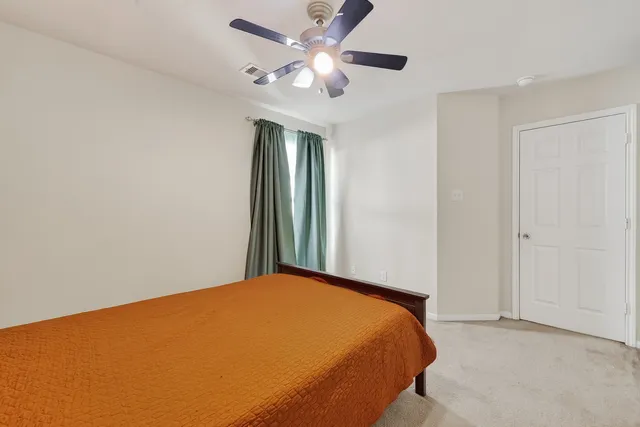 a bed room with a bed mirror and a chair