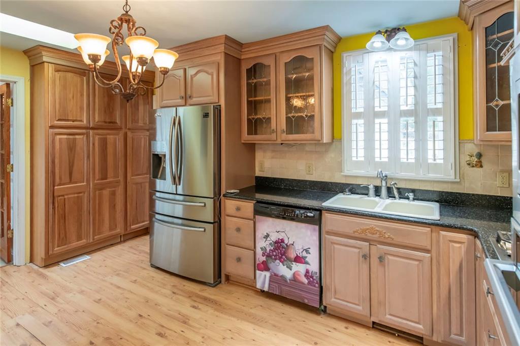 3819 Mason Creek Road Winston, GA 30187 - Photo 19 of 52 a kitchen with stainless steel appliances granite countertop a refrigerator a sink dishwasher a dining table and chairs with wooden floor