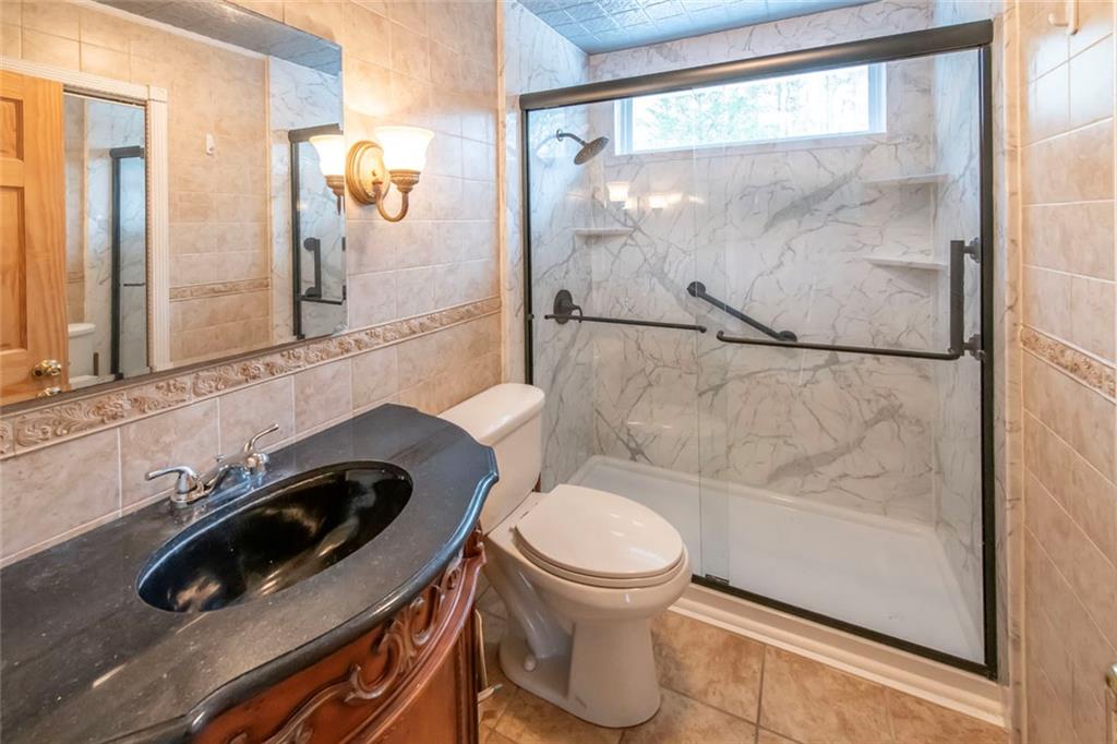 3819 Mason Creek Road Winston, GA 30187 - Photo 24 of 52 a bathroom with a sink a toilet and a shower