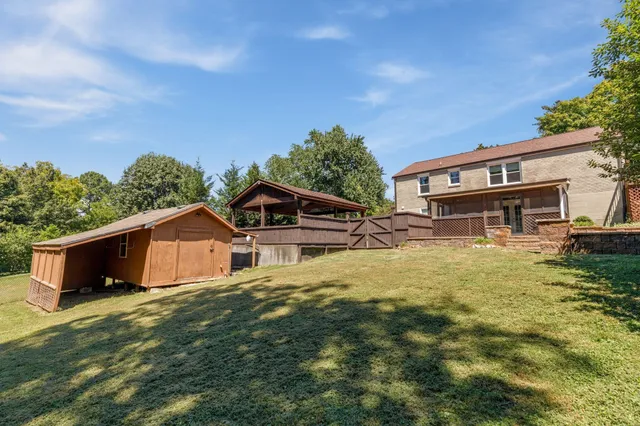 a front view of house with yard and trees in the background