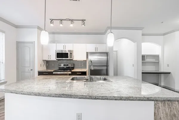 a kitchen with stainless steel appliances granite countertop a sink refrigerator and microwave