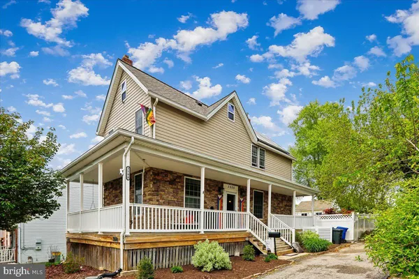a front view of a house with a tree