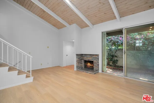 a view of an empty room with a fireplace and a floor to ceiling window