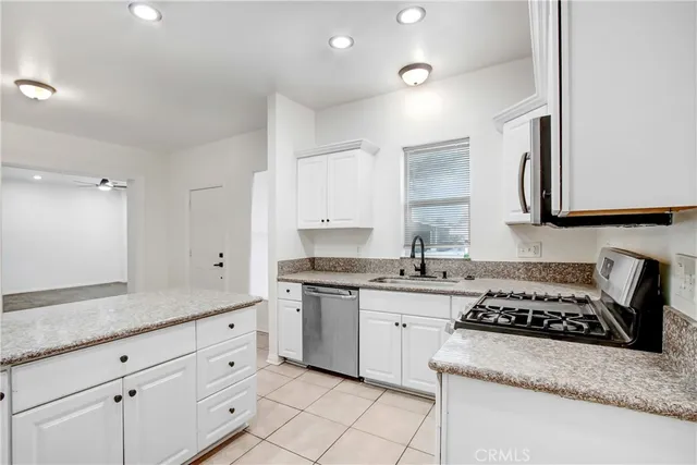 a kitchen with white cabinets appliances and a sink