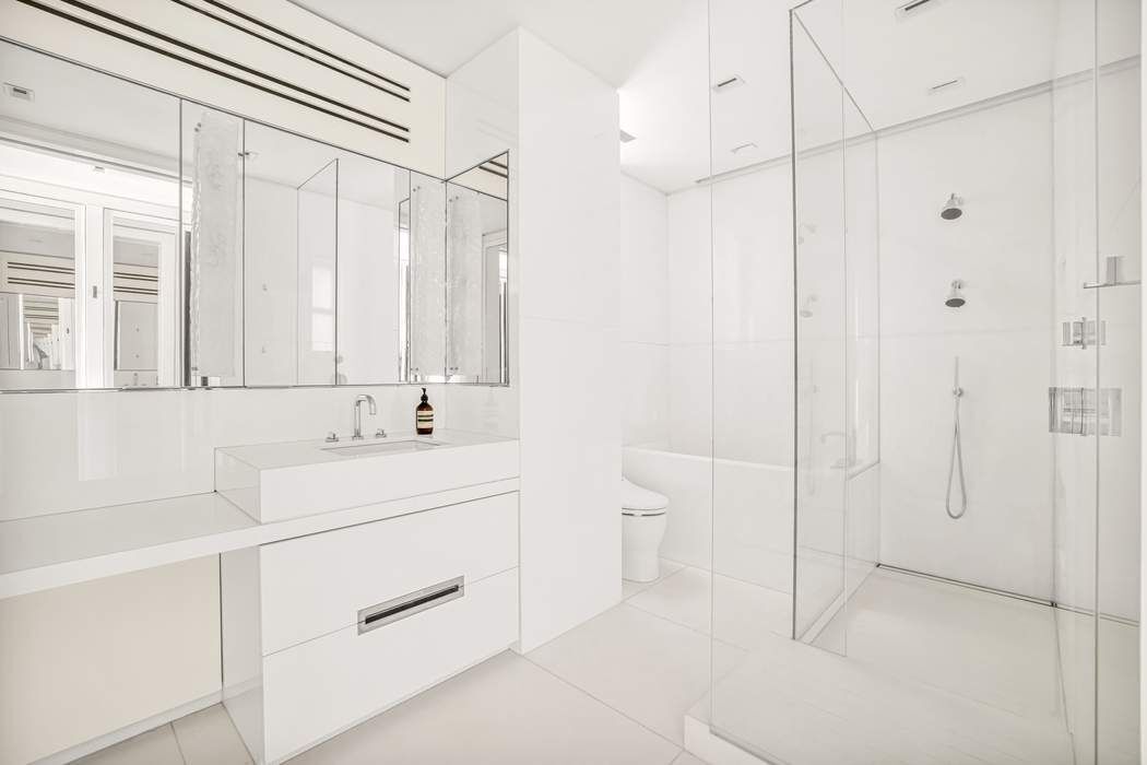 825 5th Avenue, Unit 12C Manhattan, NY 10065 - Photo 11 of 15 a bathroom with a sink a toilet and a shower