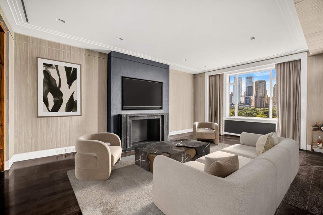 825 5th Avenue, Unit 12C Manhattan, NY 10065 - Photo 3 of 15 a living room with fireplace furniture and a flat screen tv