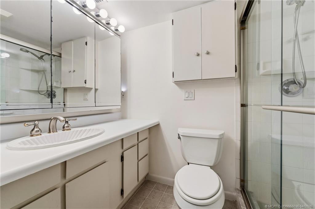 1941 Southwest Palm City Road, Unit B Stuart, FL 34994 - Photo 11 of 40 a bathroom with a toilet a sink and a mirror