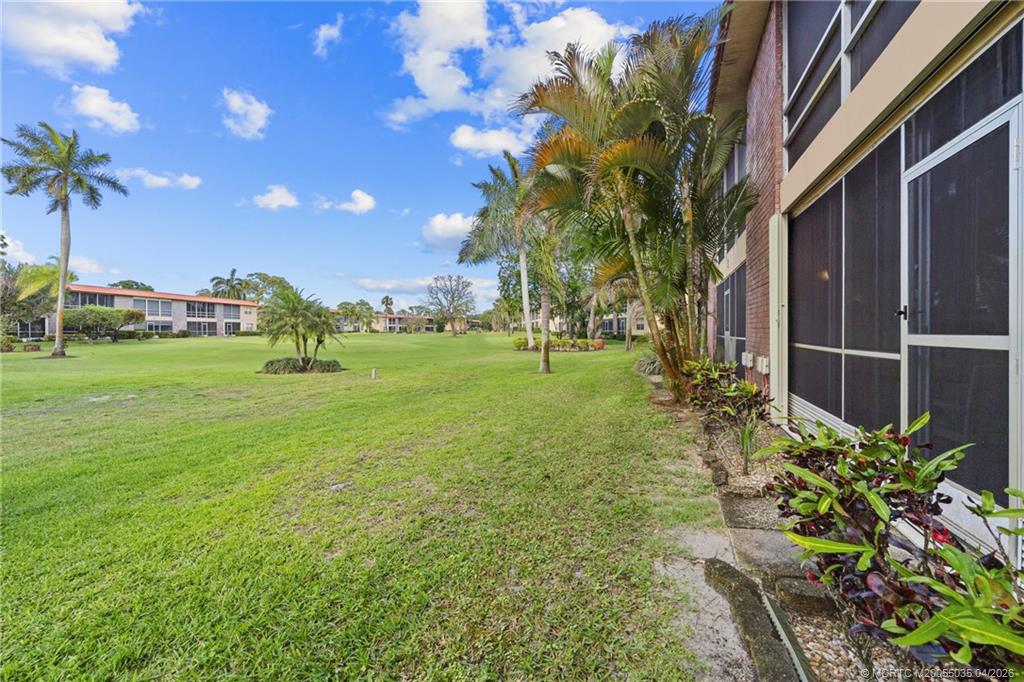 1941 Southwest Palm City Road, Unit B Stuart, FL 34994 - Photo 19 of 40 a view of a garden with a building in the background