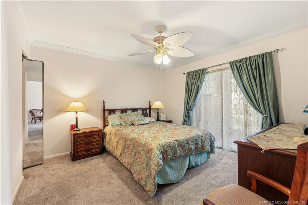 1941 Southwest Palm City Road, Unit B Stuart, FL 34994 - Photo 10 of 40 a bedroom with a bed and a chandelier