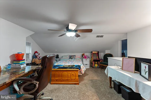 a bedroom with furniture and a fan