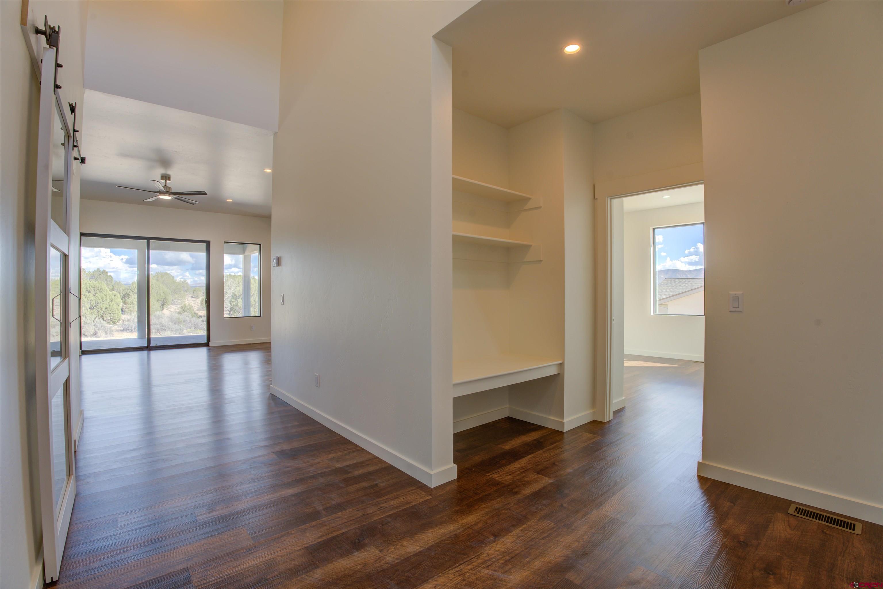 1678 Golf Course Lane Cortez, CO 81321 - Photo 4 of 28 wooden floor in an empty room with a window