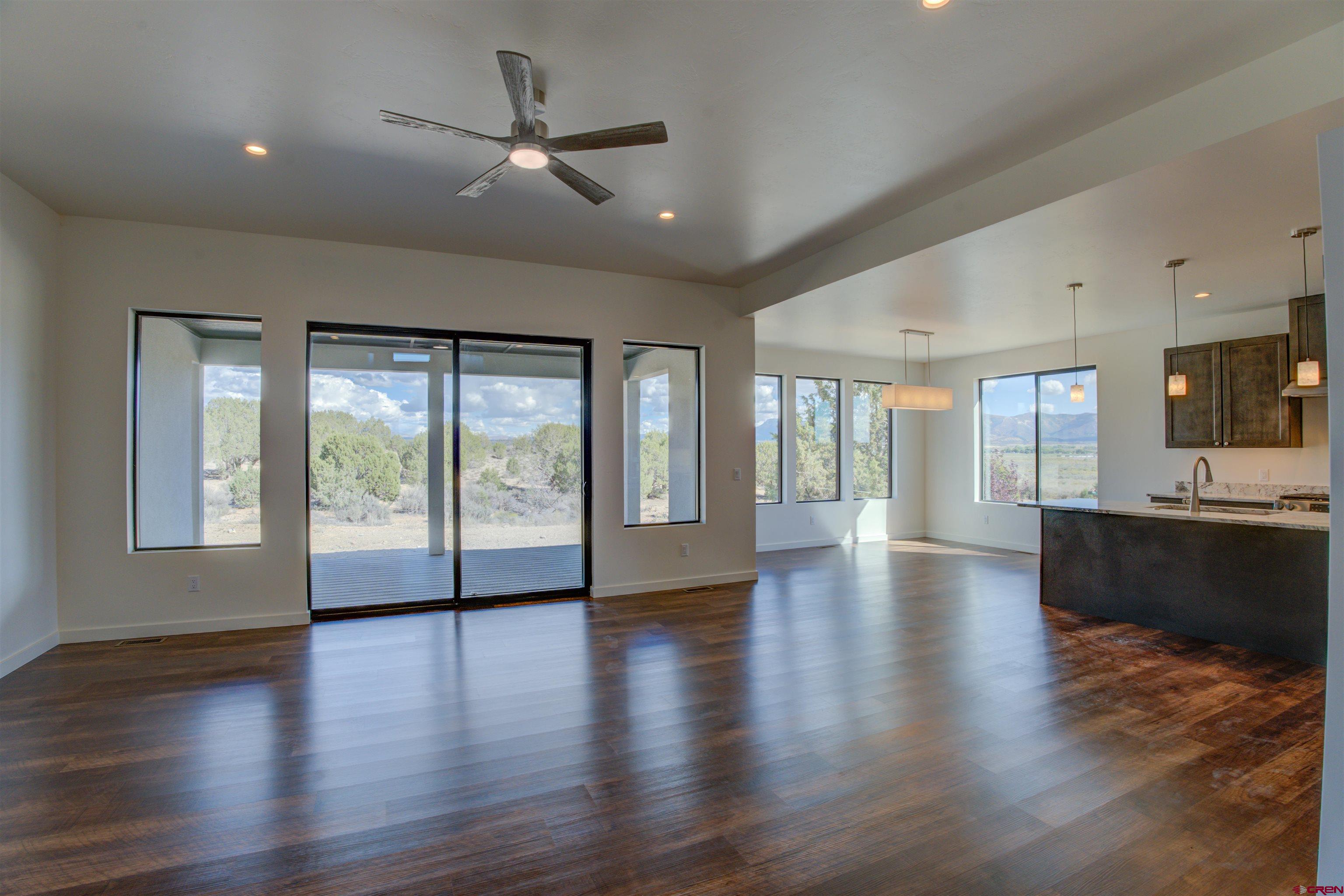 1678 Golf Course Lane Cortez, CO 81321 - Photo 5 of 28 a view of an empty room with wooden floor and a kitchen