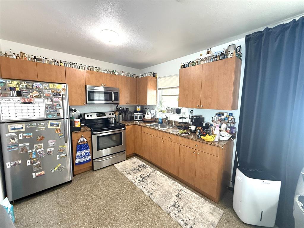 1441 Miami Road, Unit 1 Fort Lauderdale, FL 33316 - Photo 3 of 11 a kitchen with stainless steel appliances kitchen island granite countertop a refrigerator and a stove top oven