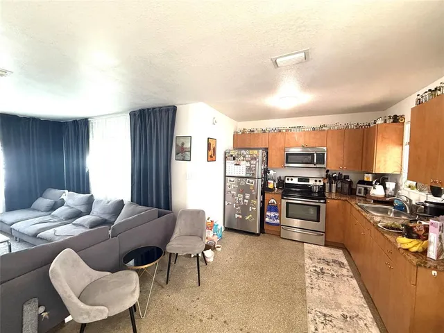 a living room with furniture kitchen view and a flat screen tv