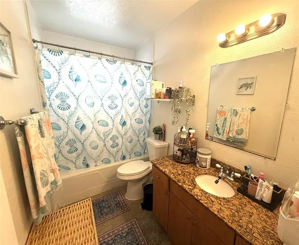 a bathroom with a granite countertop sink mirror vanity and toilet