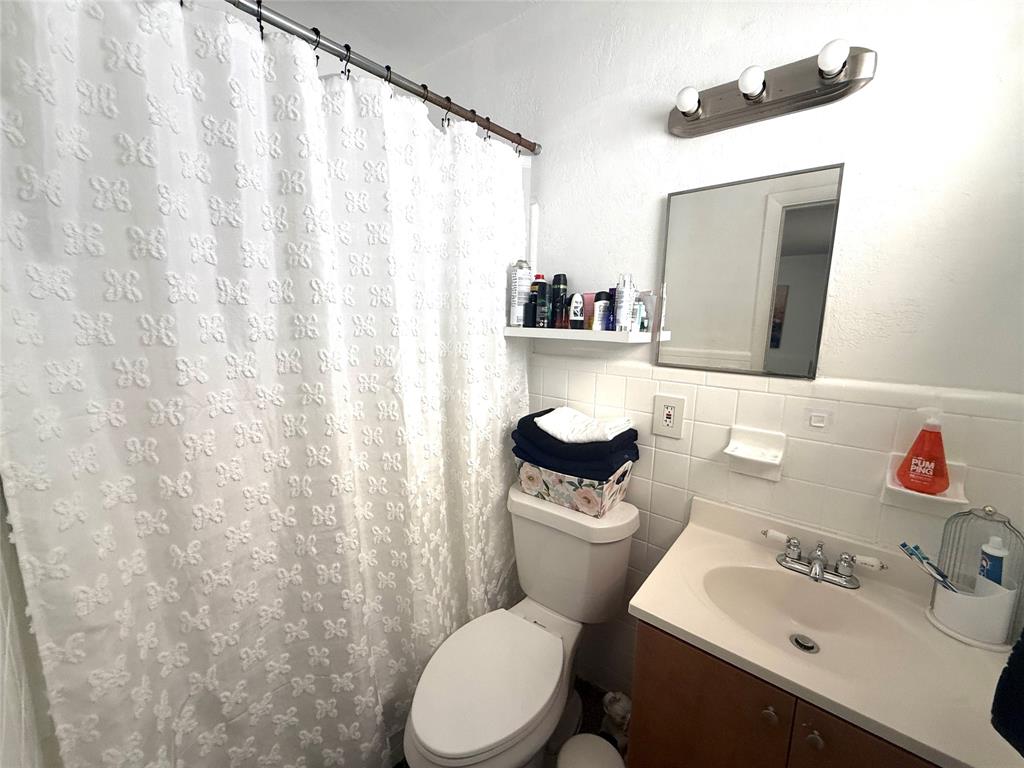 1441 Miami Road, Unit 1 Fort Lauderdale, FL 33316 - Photo 8 of 11 a bathroom with a sink a toilet and a mirror