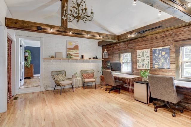 a work room with furniture wooden floor and windows