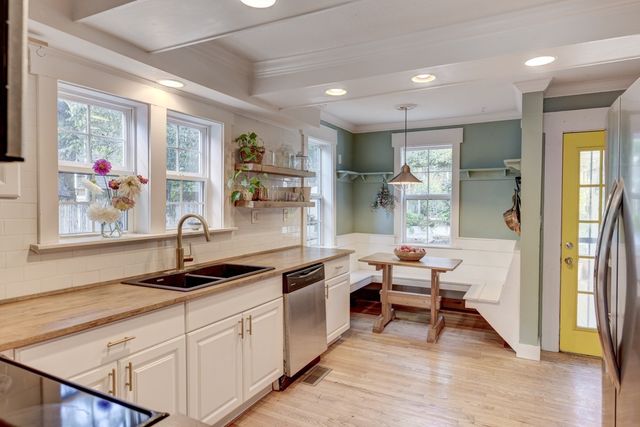 a kitchen with stainless steel appliances granite countertop a sink and wooden cabinets