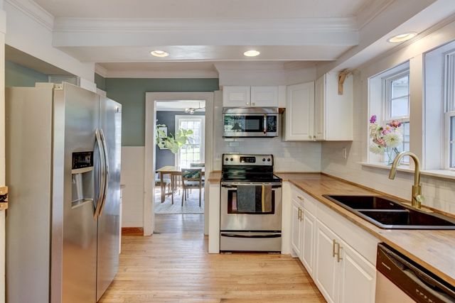 a kitchen with granite countertop a refrigerator stove and sink